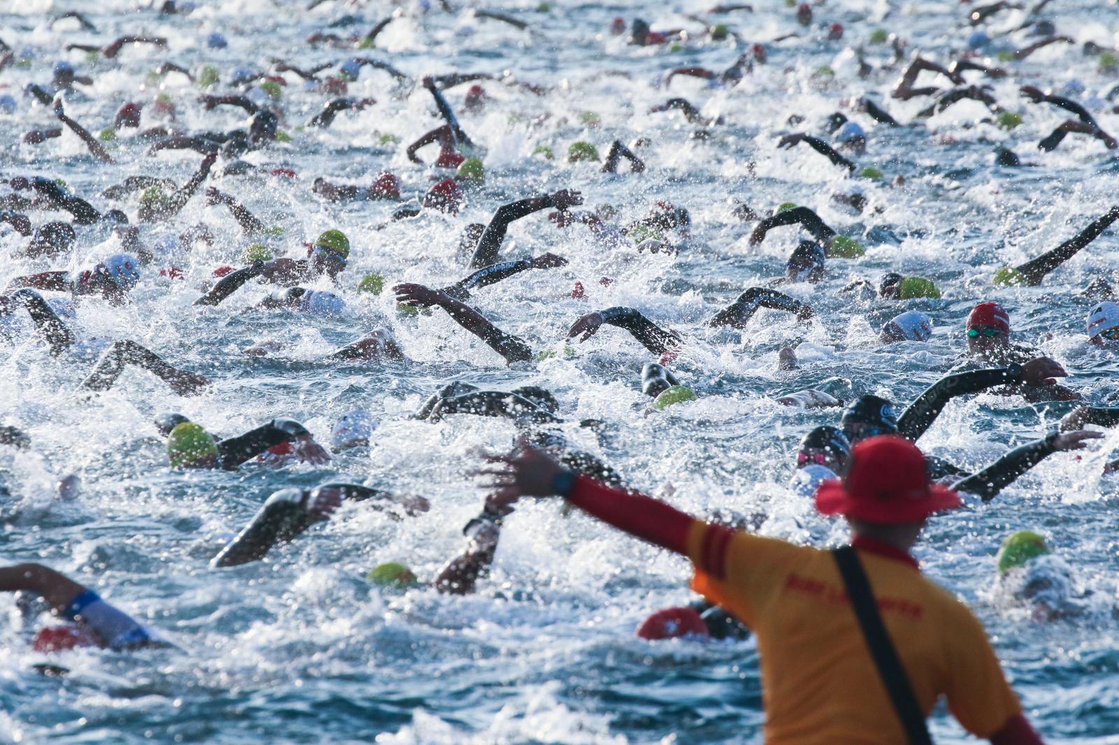 Triathletes swimming at the start of a triathlon